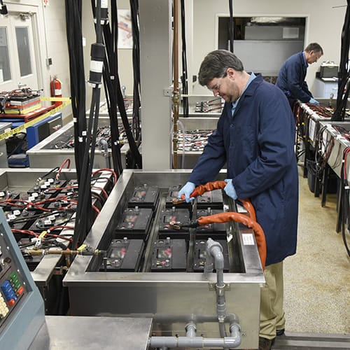 person working on car batteries